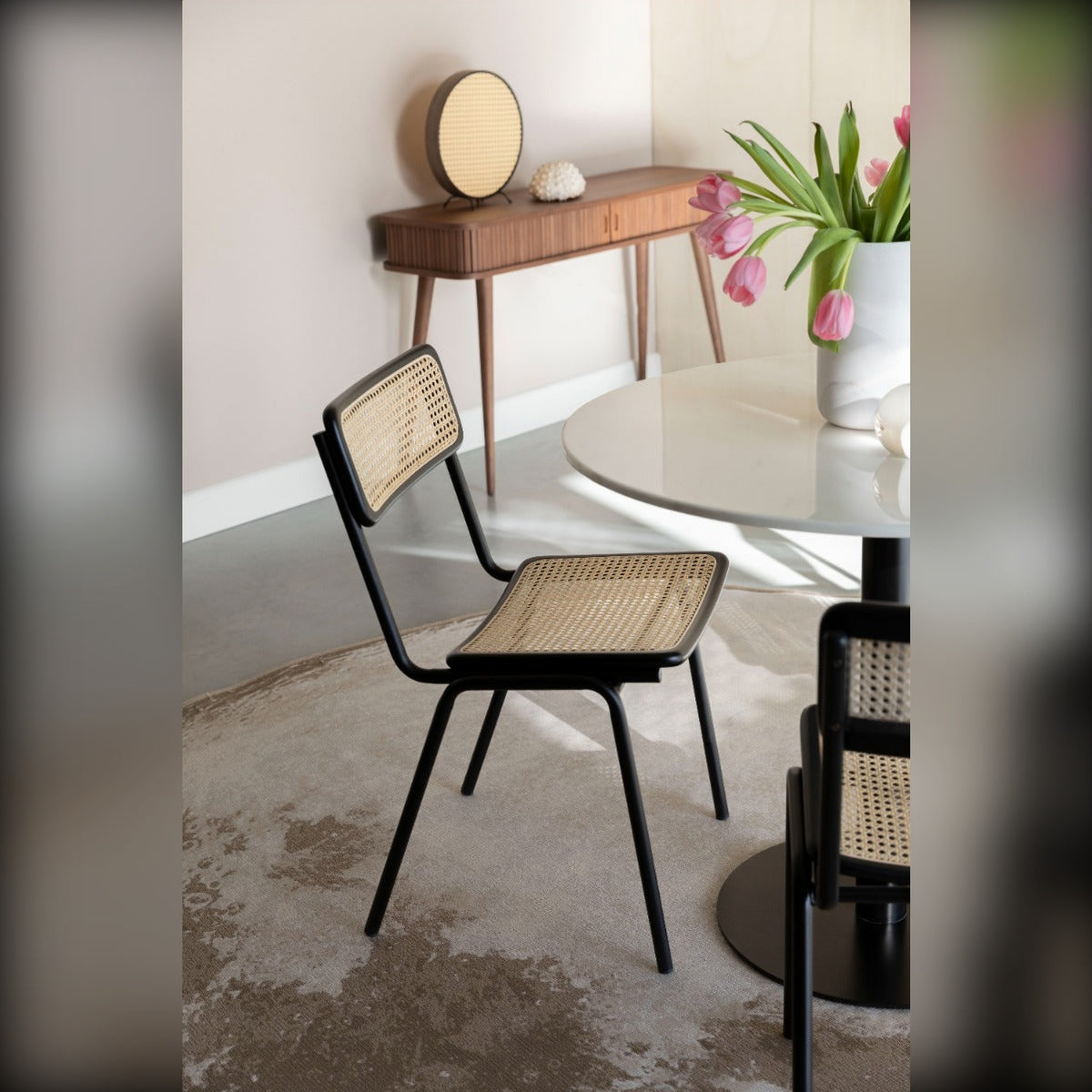 Dining Chair Jort Natural Black Domestica – Lifestyle – Angled at a Round White Table with Flowers