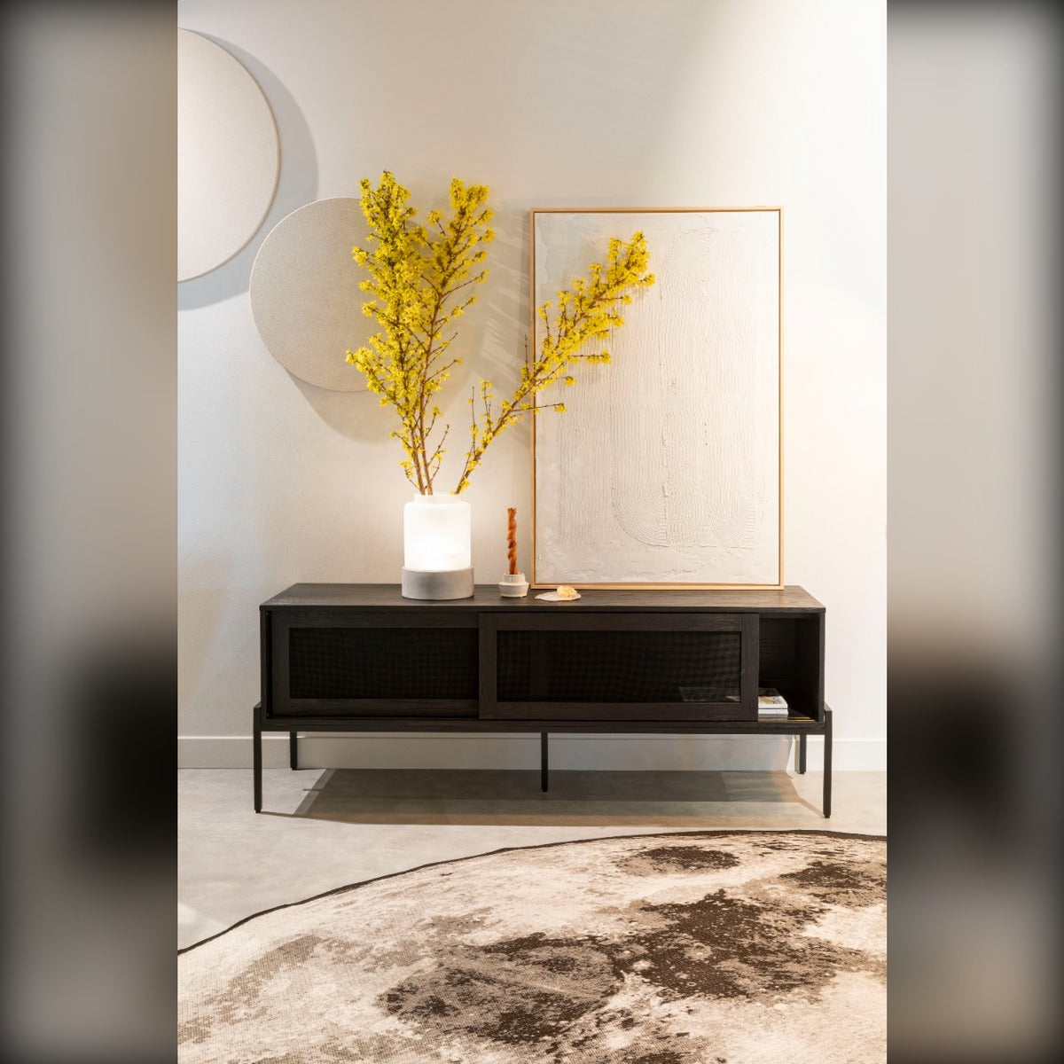 Sideboard Hardy Black Oak Domestica – Lifestyle – With Yellow Flowers and a Round Rug