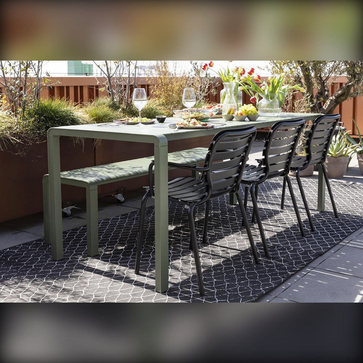 Garden Chair Vondel Black Domestica – Lifestyle – At a Long Green Outdoor Table