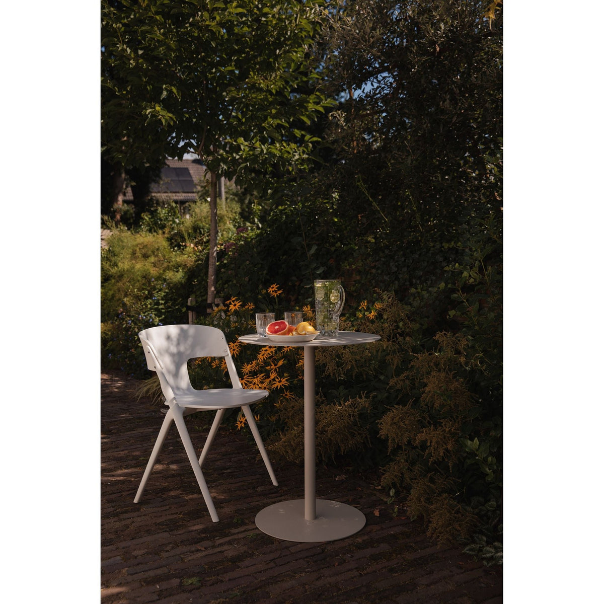 Outdoor Chair Horizon Off-White Domestica – Lifestyle – At a Garden Bistro Table on a Brick Patio