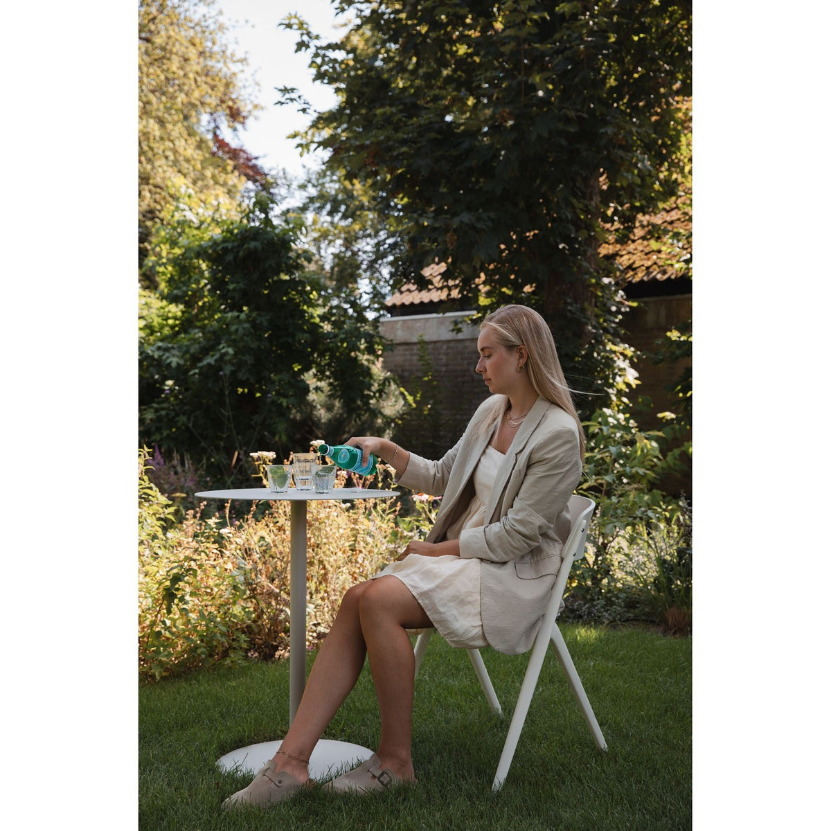 Outdoor Chair Horizon Off-White Domestica – Lifestyle – Seated at a Garden Table on the Lawn