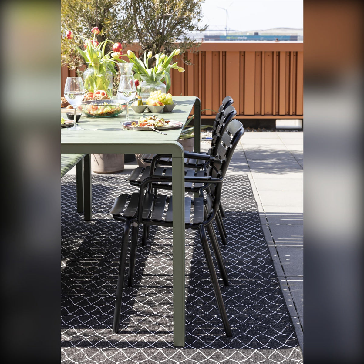 Garden Chair Vondel Black Domestica – Lifestyle – At a Long Green Outdoor Table, Portrait