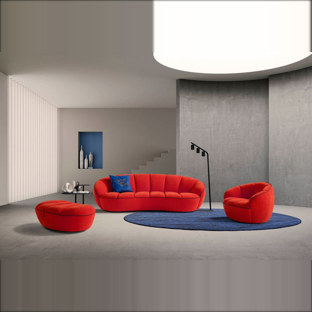 Egoitaliano Shai 3-Seater Curved Sofa Red Fabric Domestica – Lifestyle Interior with Armchair and Pouf Tondo