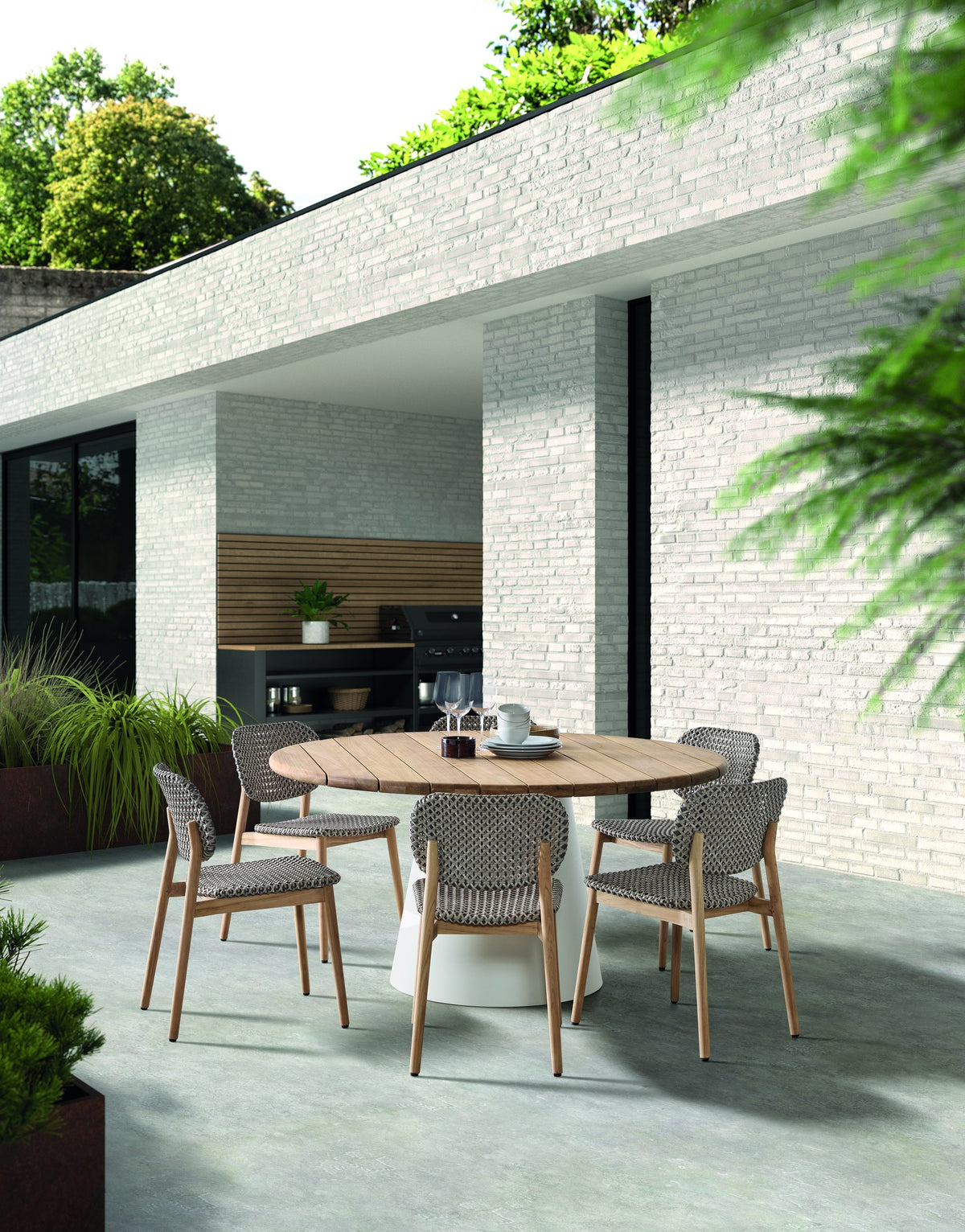 Dining Table Apollo D150 Teak Natural Alu Sand Domestica – Lifestyle – Outdoor Dining with Chairs on a Patio