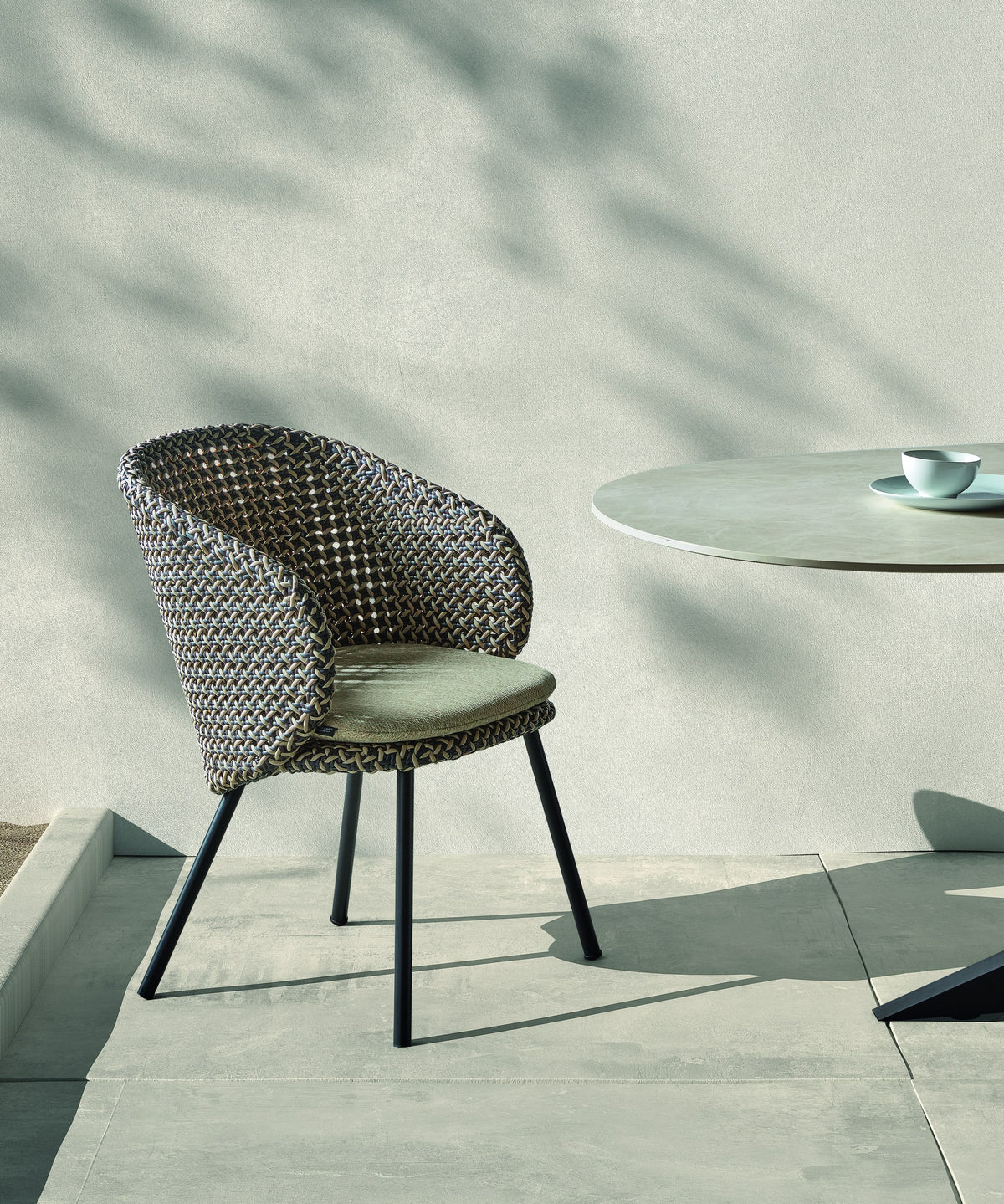 Armchair Modesto Black Alu Oyster Cream Domestica – Lifestyle – On a Sunny Terrace by a Round Table