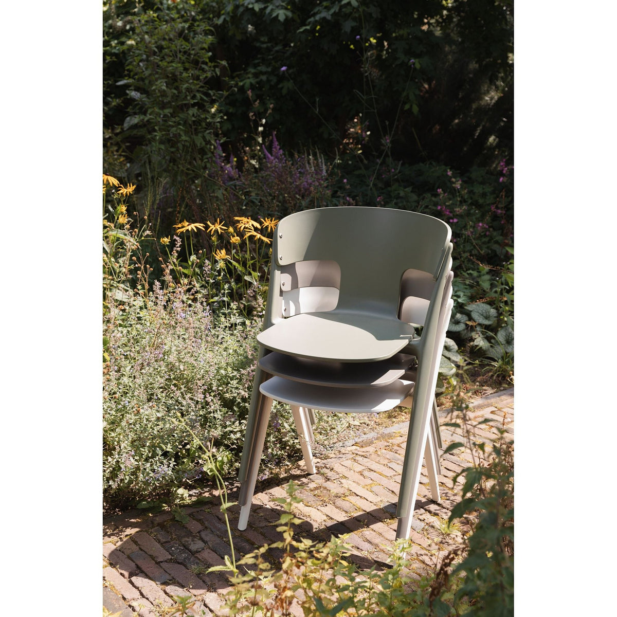 Outdoor Chair Horizon Off-White Domestica – Lifestyle – Stacked Chairs in a Garden