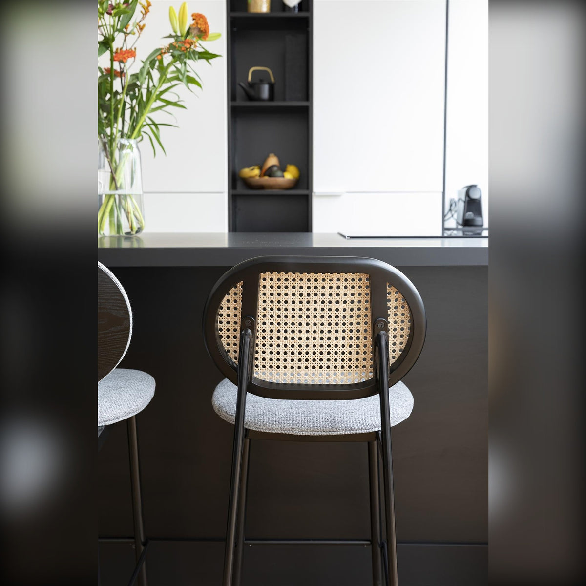 Counter Stool Spike Natural Grey Domestica – Lifestyle – Rattan Backrest at a Black Kitchen Island