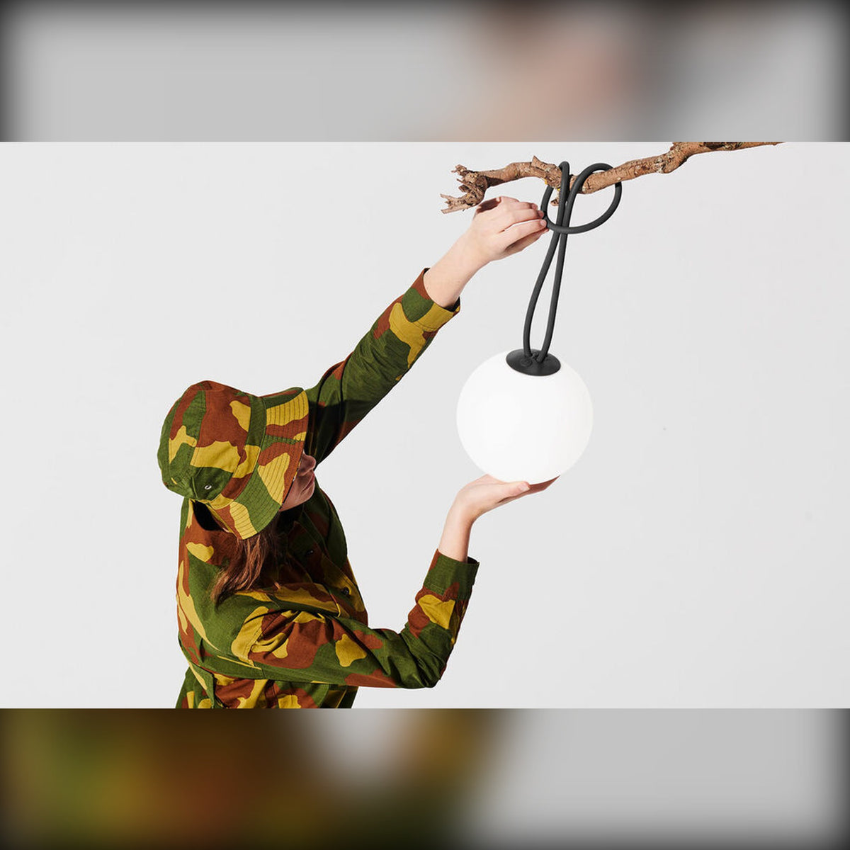 Bolleke Anthracite Domestica – Lifestyle – Person Hanging the Lamp on a Branch