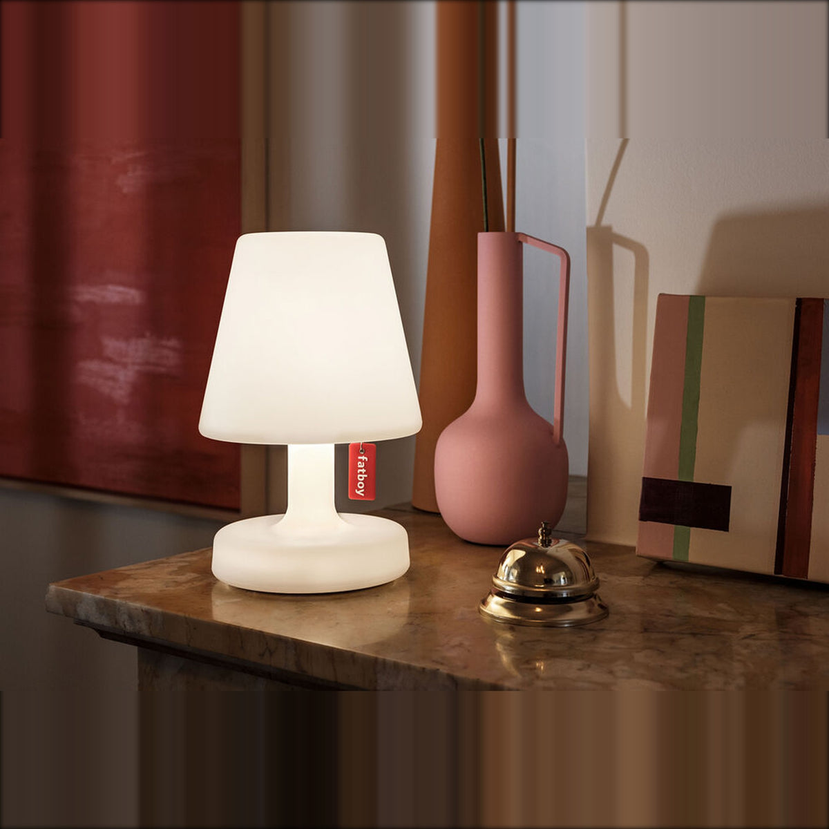 Edison the Petit White Domestica – Lit Lamp on a Wooden Sideboard