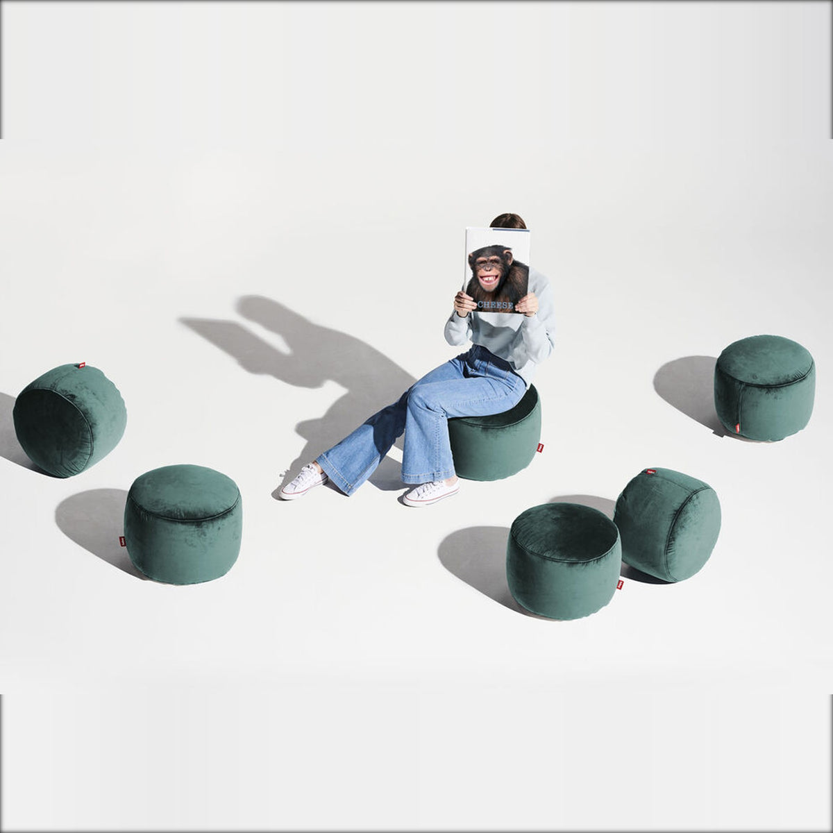 Point Velvet Petrol Domestica – Lifestyle – Person Seated Among Six Poufs