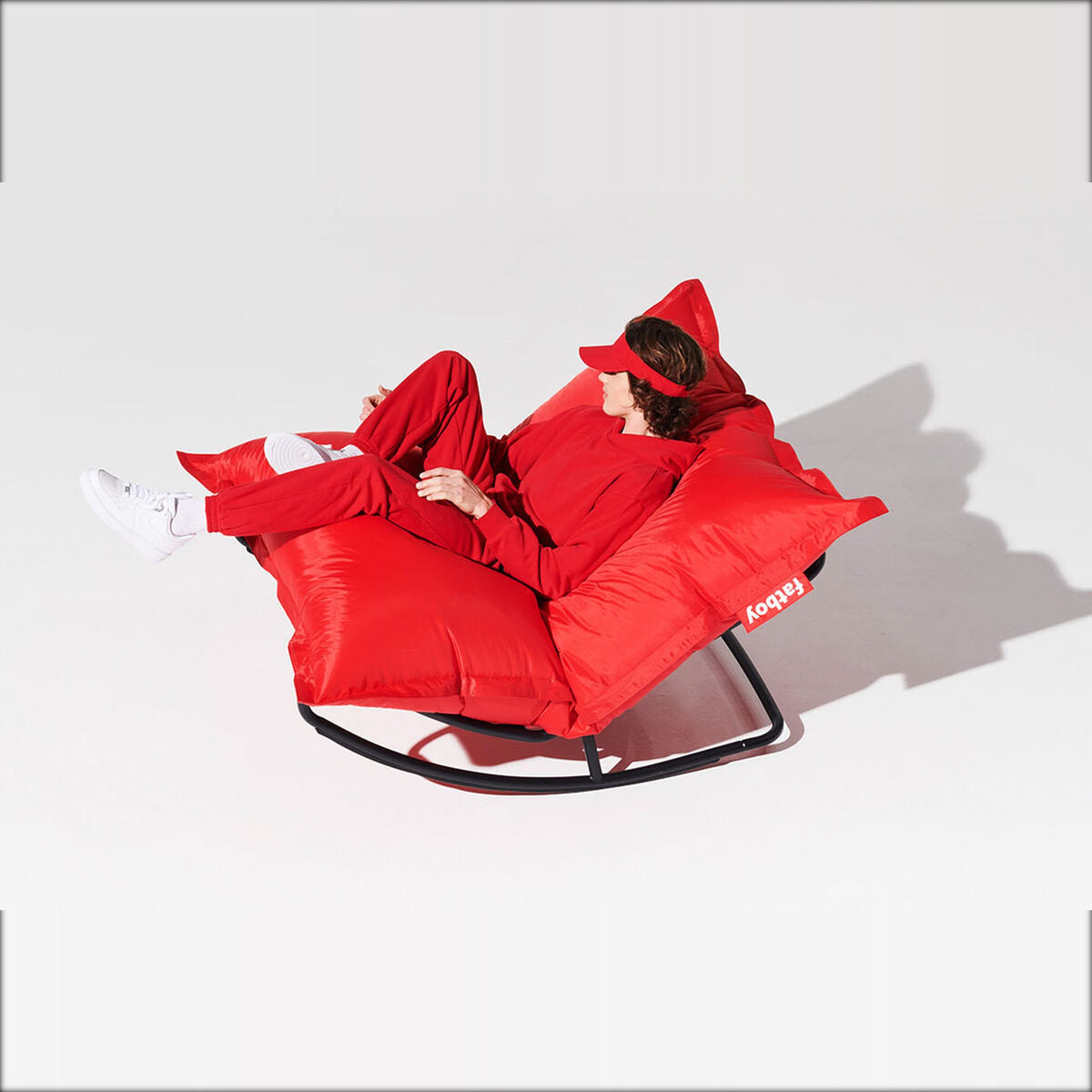 Rock 'n Roll Black Domestica – Person Lounging on a Red Cushion on the Frame, on White