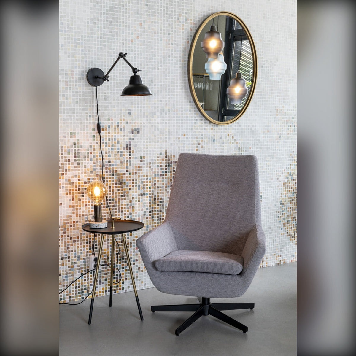 Mirror Matz Oval M Antique Brass Domestica – Lifestyle – Above a Grey Lounge Chair and Wall Lamp