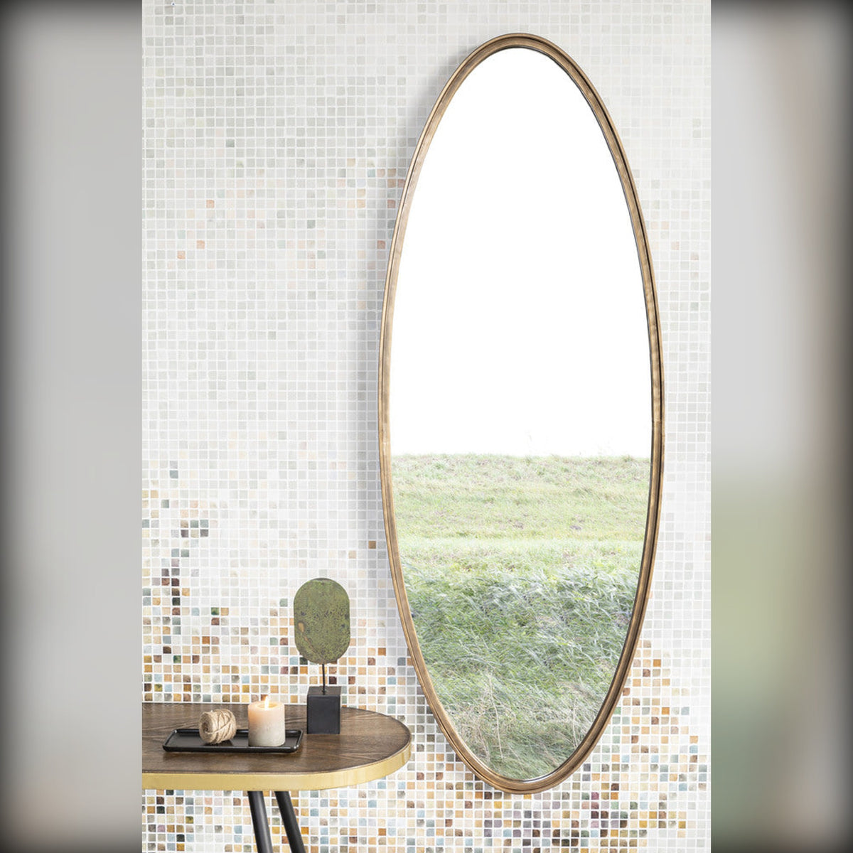 Mirror Matz Oval L Antique Brass Domestica – Lifestyle – On a White Brick Wall Above a Console with Greenery