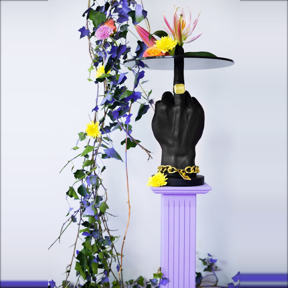 Side Table Fother Mucker Black Domestica – Lifestyle – On a Lilac Plinth with Flowers