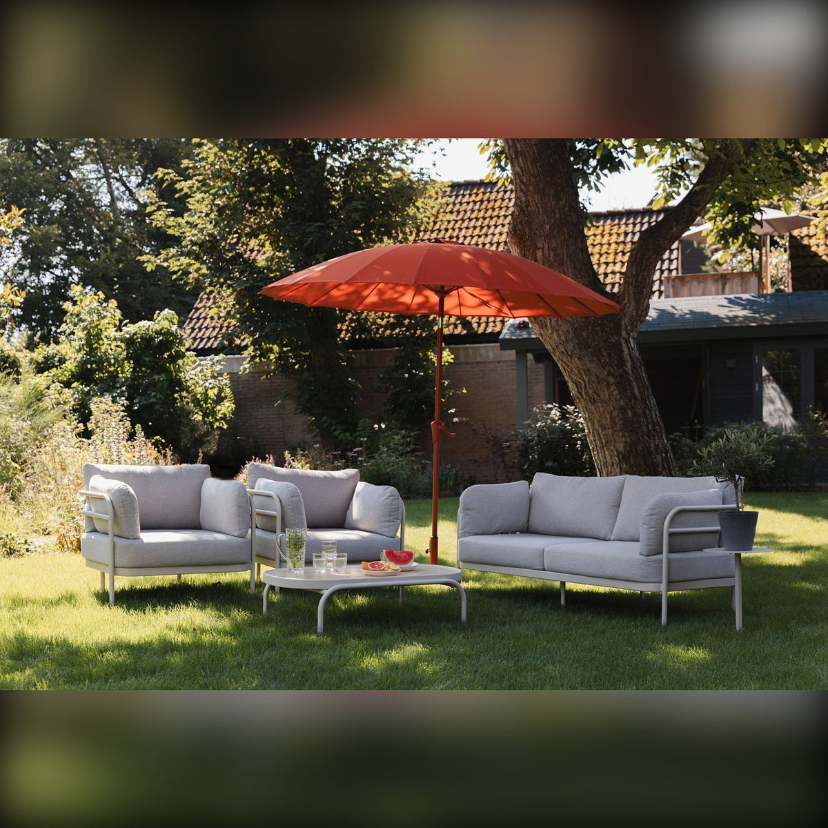 Outdoor Set Vista Beige Domestica – Lifestyle – In a Garden with Red Parasol